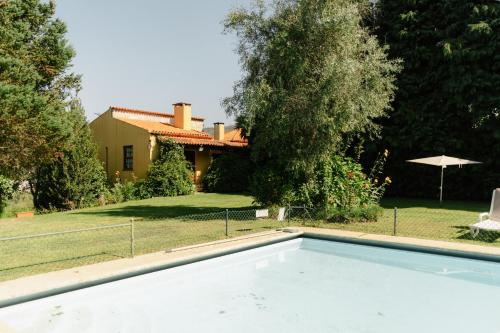 a swimming pool in front of a house at Quinta do Pomarinho - by RowdHouses in Arouca