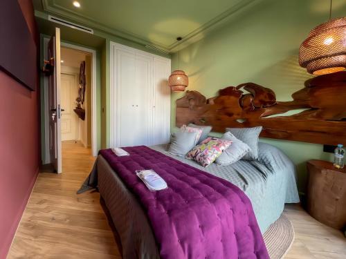 a bedroom with a large bed with a purple blanket at Maya Suites - Premium Luxury Stay in Casablanca