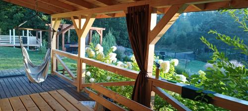 a porch with a swing and cacti at Domek pod Dębami Bogaczewo in Bogaczewo