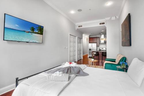 a bedroom with a white bed with a tv on the wall at XL Studio - Modern Studio with Rooftop Pool in Philadelphia