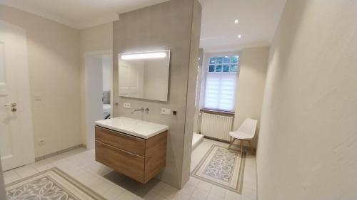 a white bathroom with a sink and a mirror at Forsthaus Hausbach - Ferienwohnung Hirsch in Losheim