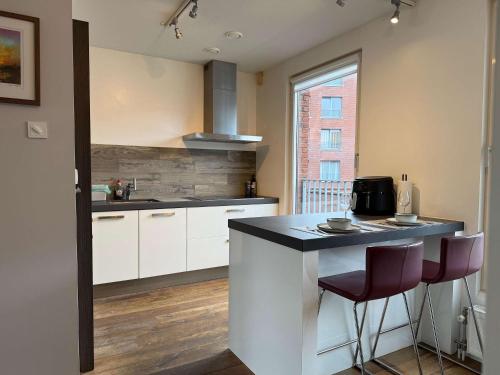 a kitchen with white cabinets and a black counter top at Spacious Family Home and Free Parking in Eindhoven in Eindhoven
