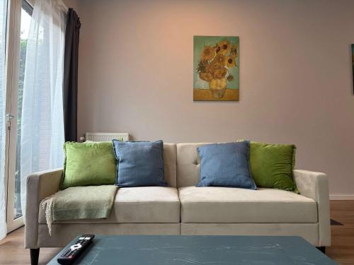 a living room with a couch with blue and green pillows at Spacious Family Home and Free Parking in Eindhoven in Eindhoven