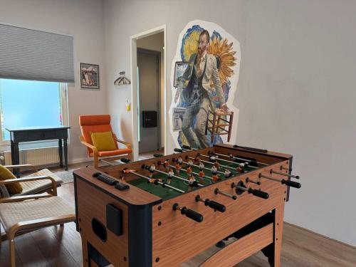 a living room with a foosball table and a mural at Spacious Family Home and Free Parking in Eindhoven in Eindhoven