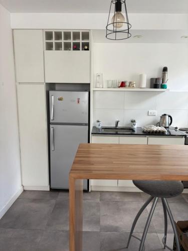 eine Küche mit einem Kühlschrank und einem Holztisch in der Unterkunft Departamento Roca in La Porteña