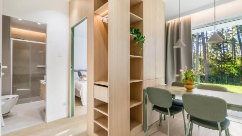 ステグナにあるSTEGNA PARK II blisko plaży Apartamenty Piamolaのテーブルと椅子、バスルームが備わる客室です。