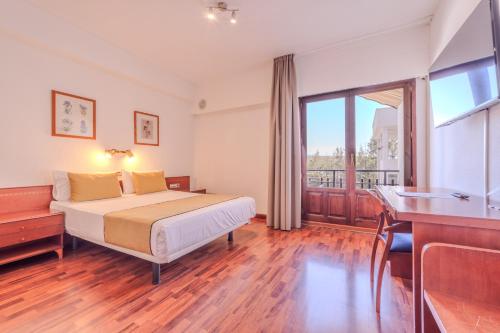 a hotel room with a bed and a balcony at ITC Ciudad de Haro by Soho Boutique in Haro