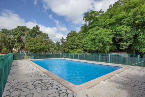 a swimming pool with a fence and trees at Casa Noel in Linguizzetta