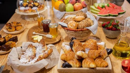 a table topped with lots of different types of pastries at Oberthaler Hotel in Sappada
