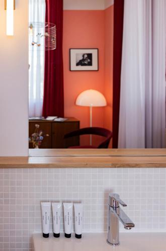 ein Badezimmer mit Waschbecken und Spiegel in der Unterkunft Vesper Hotel in Noordwijk aan Zee