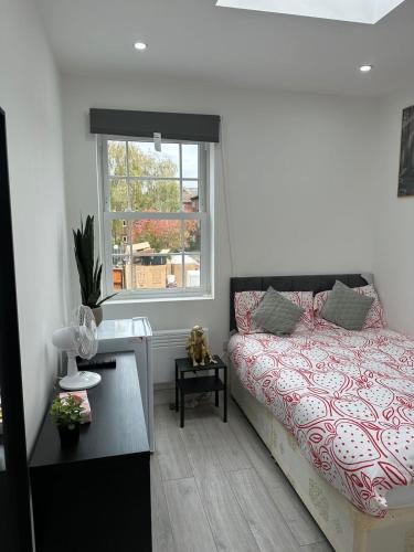 a bedroom with a bed and a window at The Cosy one in Sutton