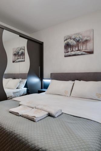 a bedroom with a large bed with white pillows at Apartman Nada de lux in Vrnjačka Banja