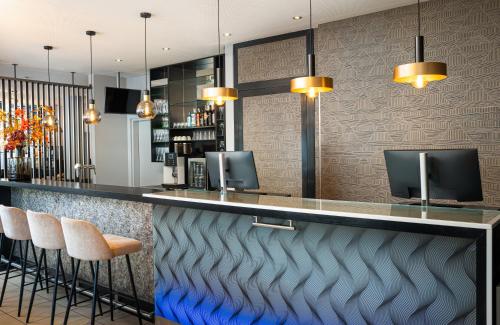 ザルツブルクにあるLeonardo Hotel Salzburg City Centerのスツールのあるレストランのバー
