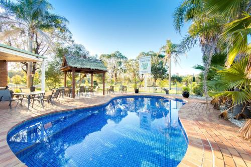 a swimming pool in a yard with a table and chairs at Thurgoona Country Club Resort in Thurgoona