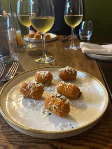a plate of donuts on a table with wine glasses at The Bath Arms Shearwater in Warminster