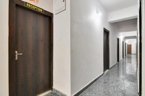 a hallway with a brown door in a building at Hotel O Kasturi And Banquet Hundur Halt in Kānke