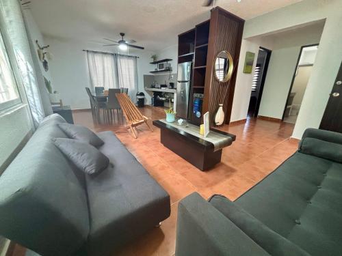 a living room with a couch and a table at Peach35 Apartamento centrico, 5 min de la playa in Cancún