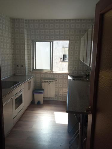an empty kitchen with a window and a kitchen floor at Acogedora habitación privada en piso familiar con baño compartido in Salamanca