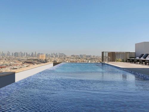 a swimming pool on the roof of a building at Aparthotel Adagio Dubai Deira in Dubai