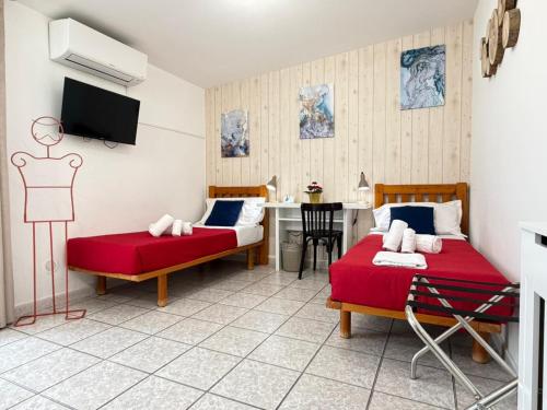 a room with two beds and a table with a tv at MIU' Bed and Breakfast in Ciampino