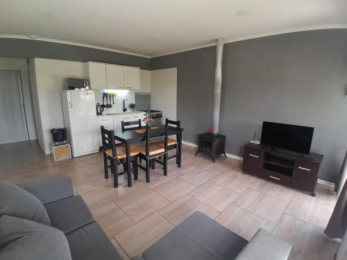 een woonkamer met een tafel en stoelen en een keuken bij Cabaña LuMa in San Rafael