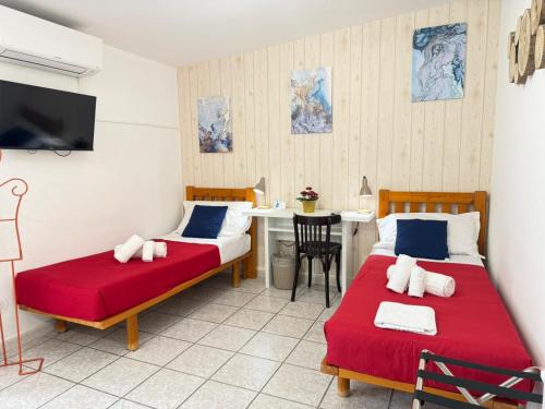 two beds in a room with a table and a tv at MIU' Bed and Breakfast in Ciampino