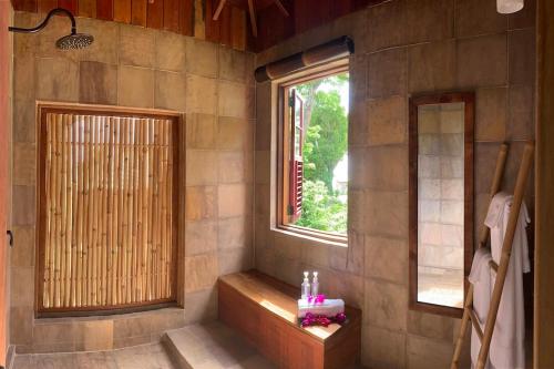 a bathroom with a window and a bench in a room at Jungle Bay Dominica in Soufrière
