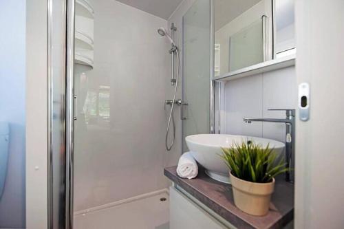 ein weißes Badezimmer mit Waschbecken und Dusche in der Unterkunft Eurocamp Mobile Homes at Campsite Puntica in Funtana
