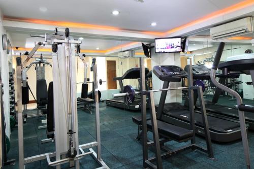 a gym with several tread machines in a room at Manila Lotus Hotel in Manila