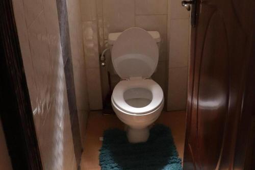 a small bathroom with a toilet with a rug at The Barn Sleeps 6 with Garden in Karuri