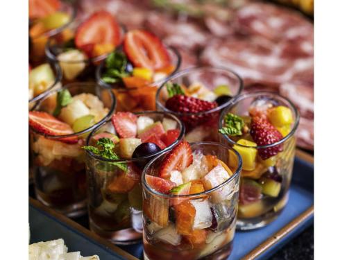 a bunch of cups filled with fruit on a tray at Novotel BH Savassi in Belo Horizonte