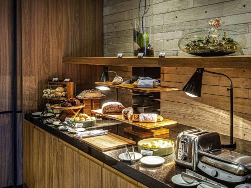 a kitchen with a buffet with food on it at Novotel BH Savassi in Belo Horizonte