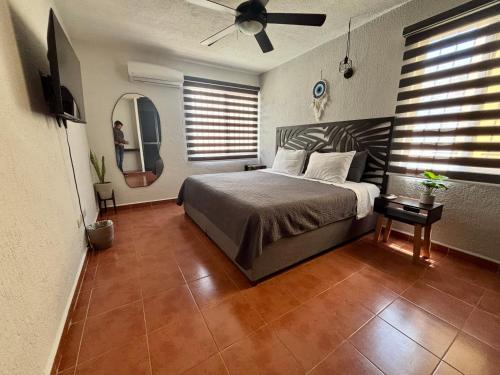 une chambre avec un lit et un ventilateur de plafond dans l'établissement Peach35 Apartamento centrico, 5 min de la playa, à Cancún