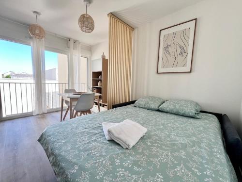 een slaapkamer met een bed en een eetkamer met een tafel bij Studio Design & Cosy - Accès Ile de Ré & Plages - WIFI PARKING GRATUIT in La Rochelle