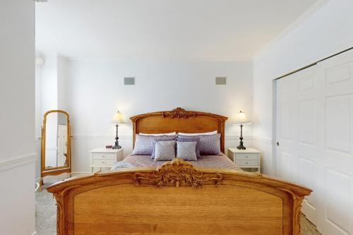 een slaapkamer met een groot houten bed met kussens bij The Abilene at Judith Ann Inn in Oyhut