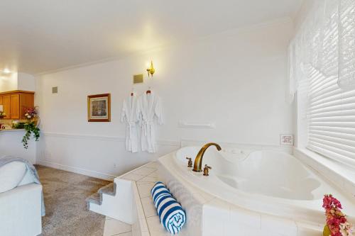 een witte badkamer met een bad en een raam bij The Abilene at Judith Ann Inn in Oyhut