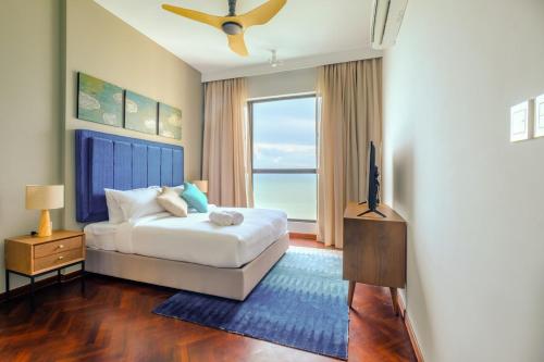 Tanjong TokongにあるPenang Beachfront Seaview Residencesのベッドと大きな窓のある寝室