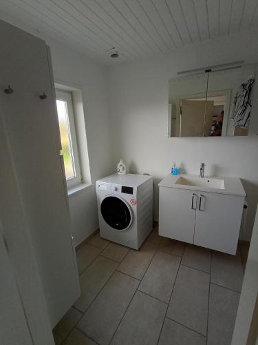 a bathroom with a washing machine and a sink at Apartment with water views in Fjerritslev