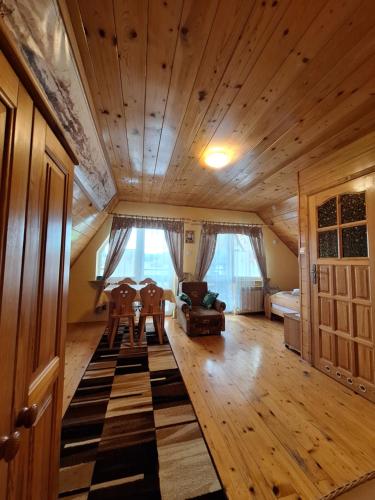 a living room with a wooden ceiling and a table and chairs at DW Jastrun in Białka Tatrzanska
