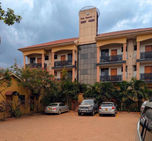 a building with cars parked in front of it at Palm Gardens Guesthouse in Kampala
