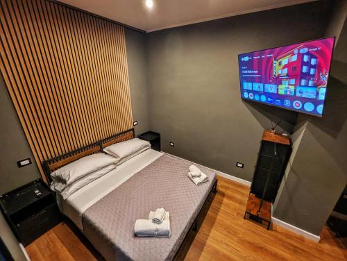 a bedroom with a bed and a flat screen tv at Palm Residence in Lamezia Terme