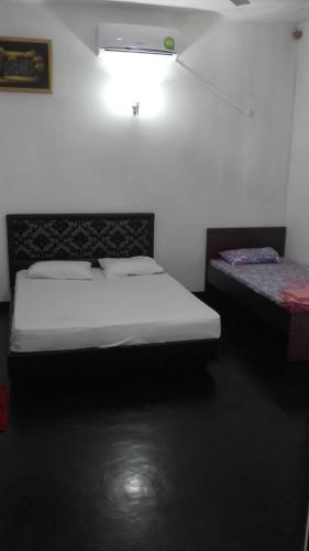 a bedroom with two beds in a room at The Kingston Hotel in Kiribathgoda