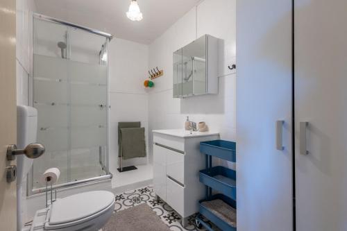 een witte badkamer met toilet en douche bij Casa Turquesa Pet-Friendly, Riverfront Home in Constância