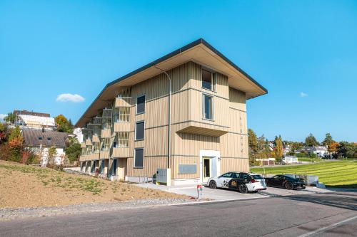 un bâtiment avec une voiture garée devant dans l'établissement VISIMO Apartments Zurich Airport, à Kloten