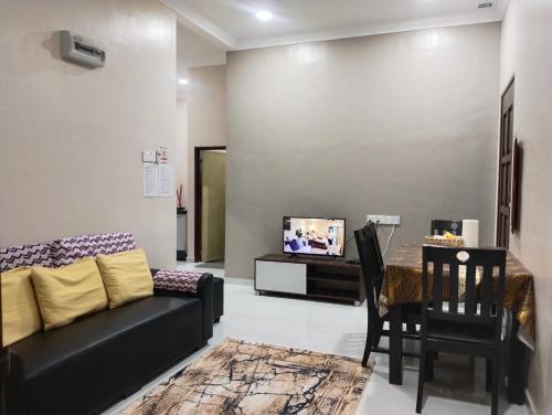ein Wohnzimmer mit Couch und Tisch in der Unterkunft Homestay Salsabila Langkawi in Kampung Padang Masirat
