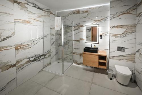 a bathroom with a shower and a toilet and a sink at R Zajazd Witnica in Witnica