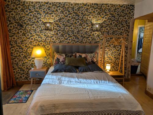 a bedroom with a bed and a wall covered in wallpaper at Gourmandise in Coutances