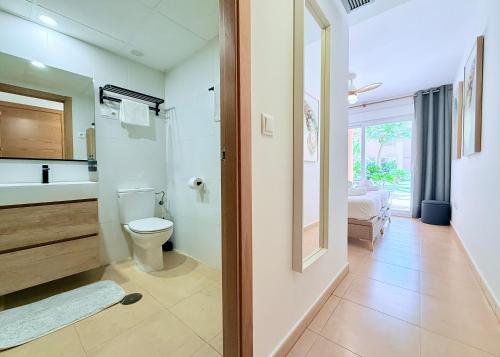 une salle de bain avec toilettes, lavabo et miroir dans l'établissement Casa Calma - Mar Menor Golf Resort, à Torre-Pacheco
