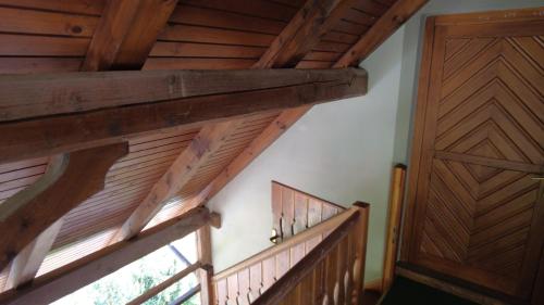 een trap met houten leuningen en een houten deur bij Apartment-Koželj in Dobrna