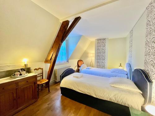 a bedroom with two beds and a sink in it at T3 Duplex dépendance du Château in Gennes